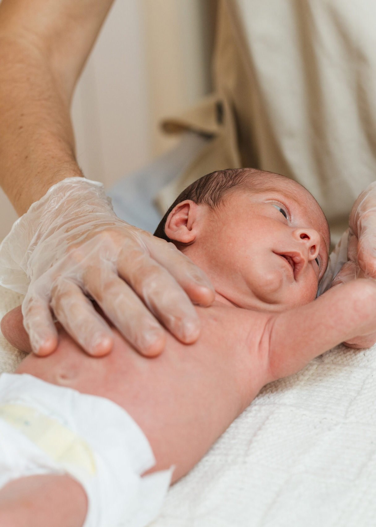 Physiotherapist performing an evaluation on a newborn baby in a therapy center. Health and medical concept.